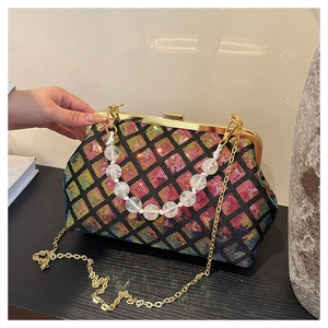 Close-up of sequin crossbody bag with gold clasp and transparent beaded handle