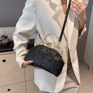 Vintage black embossed shell bag with gold metal frame and chain strap for women