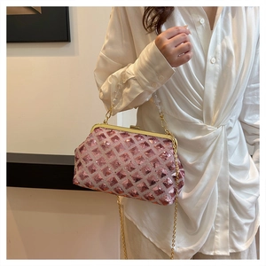 Close-up of pink sequined crossbody bag with gold frame and transparent beaded handle