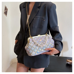 Detail of sequin shoulder bag with pearly handle and chain strap on a model