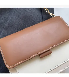 Detail shot of brown and beige patchwork crossbody bag with premium leather texture