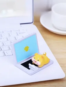 Close-up of a cute resin Shiba Inu puppy laying on a miniature purple laptop ornament