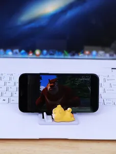 Close-up of a Shiba Inu desk phone holder with a miniature laptop detail on a white base