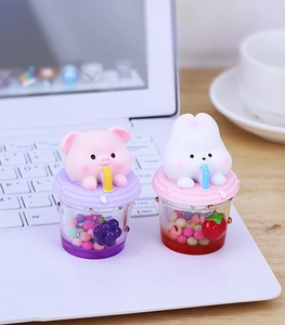 Mini figurines cochon rose et lapin blanc avec charmes de fruits sur un ordinateur