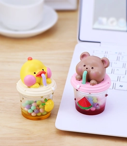 Vue détaillée de mini boissons en résine animaux sur bureau bois avec fruits décor