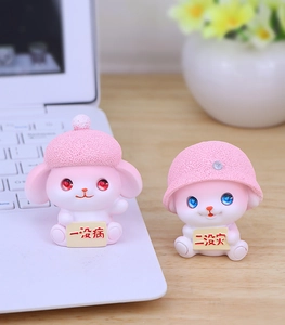 Cute pink resin puppy figurines with tiny hats displayed on a cozy wooden office desk