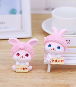 Detailed view of pink resin bunny figurines with knit textures and warm lifestyle backdrop