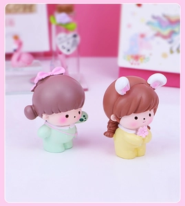 Detailed close-up of two cute resin girl figurines for office desk and car decor