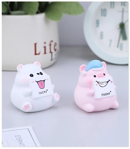 Dettaglio di simpatiche statuette in resina di orso e maiale con cartelli Lucky e Happy
