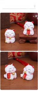 Detailed close-up of cute ceramic Maneki-Neko kittens on traditional wooden base