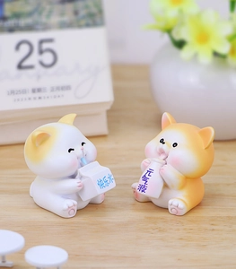Detail of two cute resin animal figurines holding juice boxes on a wooden table