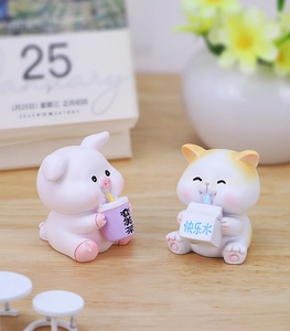 Close-up of resin pig and hamster figurines holding cute drink containers on wood