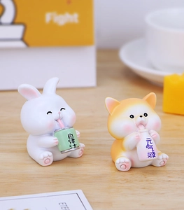 Close-up of cute resin animal figurines on wood, featuring a rabbit and cat with drinks