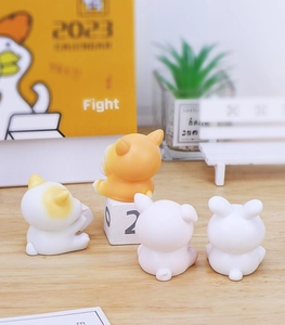 Rear view of four cute resin animal figurines on a desk with a yellow calendar and plants