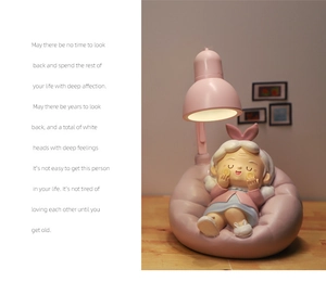 Close-up of a pink cartoon girl figurine lamp on a wooden table with warm lighting