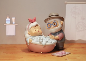 Detail of elderly couple miniature scene with pink bathtub and warm bathroom decor
