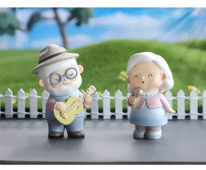 Miniature elderly couple figurine set with grandfather playing guitar and grandmother singing
