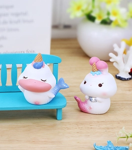 Détail macro de figurines chat sirène féerique avec décor de glace sur bureau en bois