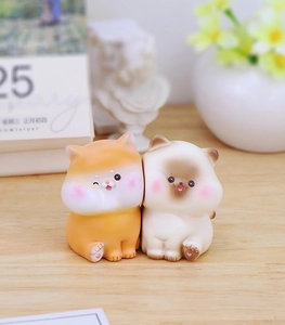 Close-up of cute resin animal desktop ornaments in orange and creamy white colors