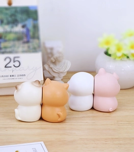 Set of four cute animal desk ornaments in pastel colors on a wooden surface with decor