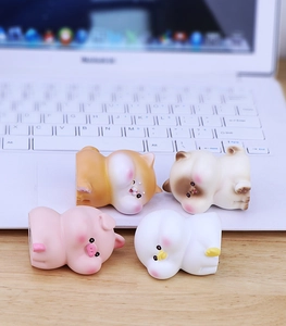 Close-up of four cute animal figurines perched on a laptop screen for desk decoration