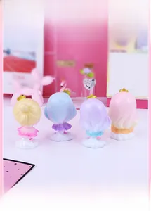 Detail view of four cute princess cake toppers with ballet tutus on white cloud bases