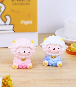 Cute resin sheep figurines with wool texture and golden bows in a cozy home setting