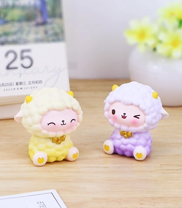 Detailed view of cute resin sheep figurines with golden horns and curly wool textures