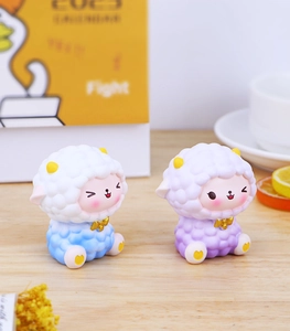 Detail of cute blue and purple resin sheep figurines with cloud texture on wood surface