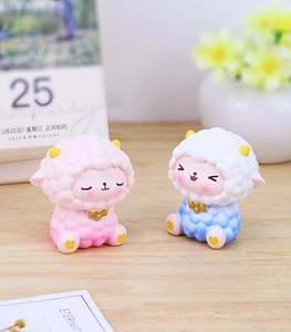 Close-up of pink and blue gradient cartoon sheep resin figurines on a cozy office desk