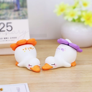Gros plan de mignonnes figurines de canard blanc avec chapeaux à fleurs et lettrage