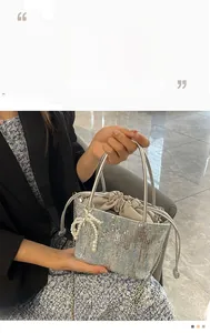 Detail of silver sequin bucket bag with pearl bow charm and drawstring closure