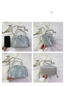 Detail view of a sequined bucket bag with pearl bow, chain strap, and drawstring closure