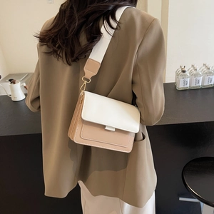 Fashionable beige color-block crossbody bag with wide shoulder strap shown on model