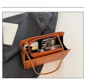 Internal view of brown quilted chain bag showing spacious compartments with daily essentials