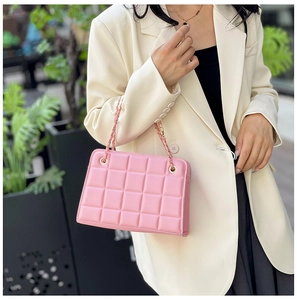 Detailed view of pink quilted chain bag with elegant stitching and golden hardware