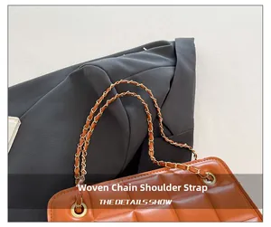 Detail of woven leather and gold chain strap on a quilted crossbody bag in orange