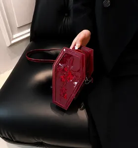 Close-up of gothic burgundy coffin bag with red rose embroidery and glossy finish