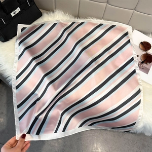 Close-up of geometric striped silk scarf with pink and blue patterns and rolled edges