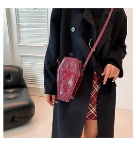 Detailed embroidery of cross and roses on a dark red coffin-shaped gothic crossbody bag