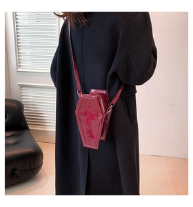 Detailed close-up of a burgundy coffin crossbody bag with embossed gothic cross and roses