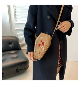 Close-up of gothic cross and red rose embroidery on khaki PU leather coffin bag