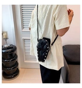 Gothic coffin shaped crossbody bag with rose relief and silver studs on a female model