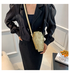 Coffin shaped crossbody bag featuring rose embroidery and silver studs shown on shoulder