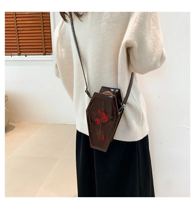 Detail of cross embossed coffin bag with red rose embroidery on brown PU leather