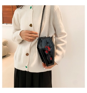 Close-up of gothic coffin bag with red rose embroidery and cross detail on glossy PU leather