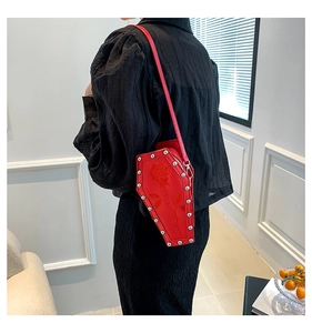 Close-up of red coffin-shaped crossbody bag with rose embroidery and silver rivets