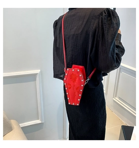 Detail of red coffin cross body bag with rose embroidery and silver studs on model