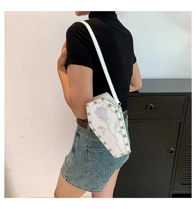Detail of coffin-shaped crossbody bag with grey rose print and silver metal rivets