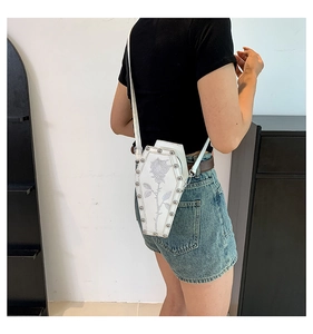 White coffin bag with gray rose embroidery and silver rivets shown on model